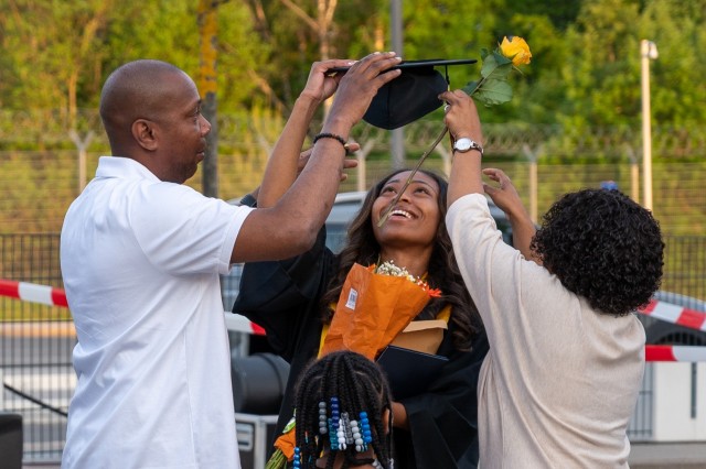 A Stuttgart High School graduate has fun while taking photos during an outdoor, drive-in graduation ceremony at Panzer Barracks, Germany, June 2, 2021.