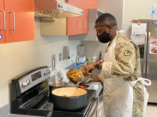 Garrison Command Sgt. Maj. Algrish Williams prepares Jamaican curry chicken for a class at Pierce Terrace Elementary School. Williams said cooking for the class is a good way to ‘truly spark their interest in a different culture through food.’