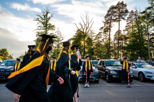 Stuttgart High School graduates approach the graduation stage during an outdoor, drive-in graduation ceremony at Panzer Barracks, Germany, June 2, 2021.