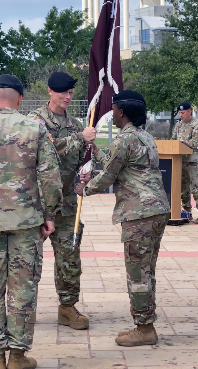 Incoming Troop Commander Lt. Col. Jody Shipley passes the guidon to Command Sgt. Maj. Stephanie Bellinger, Troop Command's senior enlisted advisor, signifying his assumption of command during a ceremony at Carl R. Darnall Army Medical Center May 28.