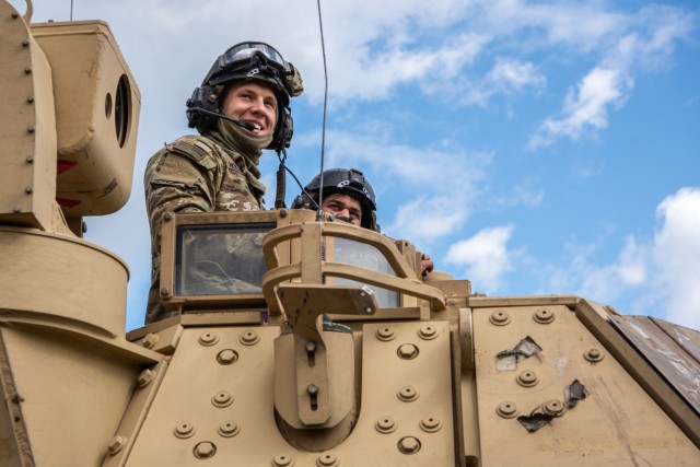Sgt. Shaun Hollenkamp, Bradley Fighting Vehicle section sergeant, 2nd Battalion, 8th Cavalry Regiment, 1st Armored Brigade Combat Team smiles as he leads troopers to their battle positions during exercise Iron Wolf in Rukla, Lithuania, May 25. 2nd...