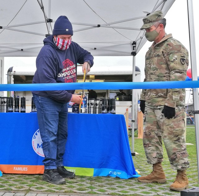 Photo by Karl Weisel
U.S. Army Garrison Command Sgt. Maj. Christopher Truchon (right) look on as Wiesbaden Entertainment Center Manager Bill Montgomery cuts the ribbon to mark the opening of the new Silver Spoon's Burger Bliss on Clay Kaserne Jan. 7, 2021.