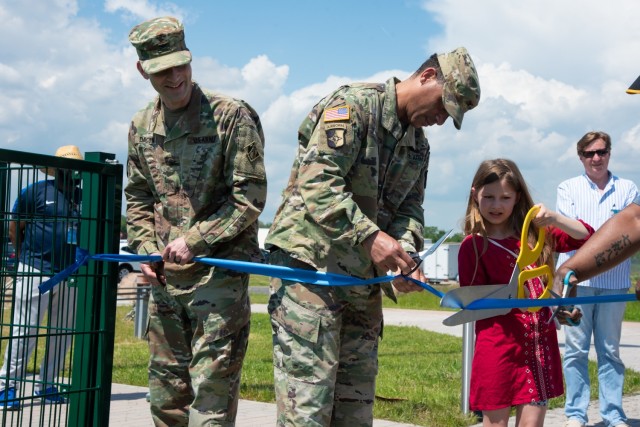 From left to right, U.S. Army Corps of Engineers, Europe District commander Col. Patrick Dagon, U.S. Army Col. Mario A. Washington, Garrison Commander, U.S. Army Garrison (USAG) Wiesbaden, and a family member participate in a ribbon-cutting ceremony for the new artificial turf field located at Clay North in Lucius D. Clay Kaserne, June 4, 2021. The turf field is the latest sports addition for U.S. Army Garrison Wiesbaden and is located next to the Family and Morale Welfare and Recreation Programs (FMWR) Recreation Center at Clay North. (U.S. Army photo by Alfredo Barraza)