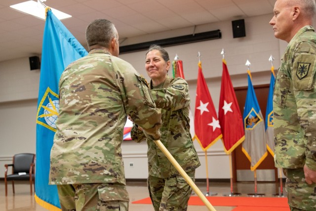 Command Sgt. Maj. Brian Bertazon (left), senior enlisted leader at Military Intelligence Readiness Command (MIRC), passes the MIRC colors to Chief of the Army Reserve Lt. Gen. Jody Daniels (center) during the MIRC's assumption of command ceremony, Fort Belvoir, Virginia, June 5, 2021. (U.S. Army Reserve photo by Maj. Jeku Arce)