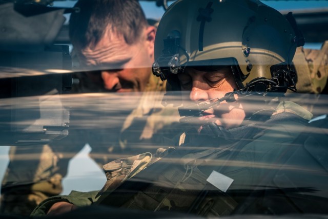 U.S. Army Lt. Col. Matthew Cole, the 1st Battalion, 3rd Aviation Regiment commander, instructs Hungarian Defense Force Brig. Gen. József Koller, the 86th Szolnok Helicopter Base garrison commander on the AH-64 Apache gunner’s controls at...