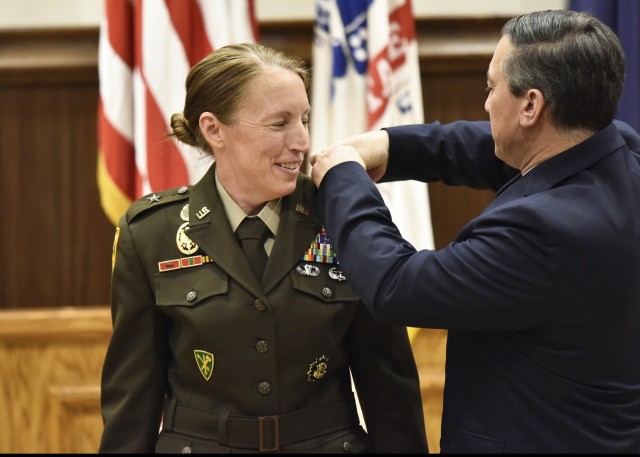 Family members of Brig. Gen. Niave Knell, U.S. Army Military Police School commandant, pin-on her new rank during a promotion ceremony June 4 at Lincoln Hall Auditorium.