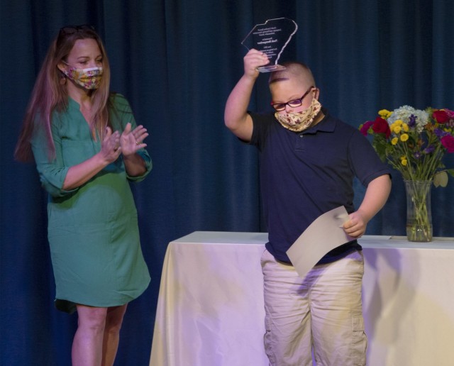 Noah Bumgarder, a sixth grader at C.C. Pinckney Elementary School raises an award over his head moments after Kerrie Ammons, Speech Pathologist for C.C. Pinckney Elementary School, announced he was named the 2021 South Carolina Speech-Language &...