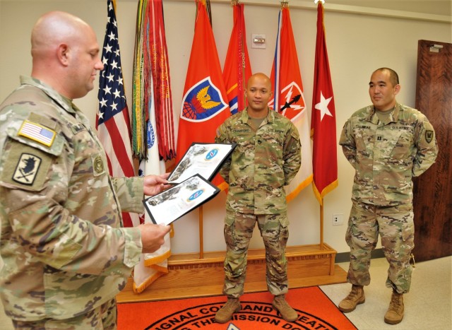 Sgt. Maj. James W. Van Zlike (left), G-3, 311th SC (T), reads the certificates of appreciation from U.S. Army Pacific G-2, June 8, 2021, to Sgt. 1st Class Jeremy Crawford (middle) and Capt. Jonathan R. Tsujimura for restoring fingerprint...