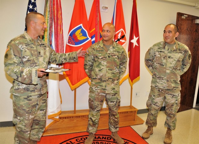 Col. Trent A. Smith, deputy commanding officer, 311th SC (T), presents certificates of appreciation from U.S. Army Pacific G-2, June 8, 2021, to Sgt. 1st Class Jeremy Crawford (middle) and Capt. Jonathan R. Tsujimura for restoring fingerprint capability of the Secure Web Fingerprint Transmission (SWFT) program to the USARPAC G-2 section. (Official U.S. Army photo by Marc Ayalin)