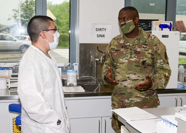 The U.S. Army Surgeon General and Commanding General, U.S. Army Medical Command, Lt. Gen. R. Scott Dingle speaks with Spc. Phillip Corona in the COVID-29 testing labratory at U.S. Army Heatlh Clinic Stuttgart on June 8, 2021. Dingle met with clinic leadership, staff and volunteers during a tour of the clinic’s facilities on Patch Barracks.