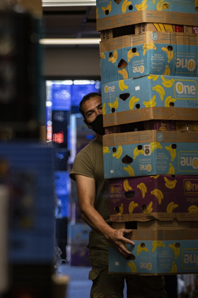 A Washington Army National Guard Soldier, assigned to Joint Task Force Steelhead, the Washington National Guard&#39;s COVID-19 response force, works with volunteers to distribute nonperishable groceries at the Kent Foodbank, June 22, 2021, in...