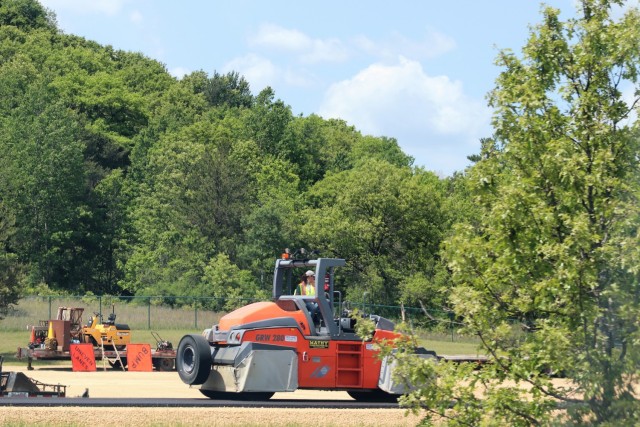 Contractors put down pavement June 2, 2021, on a road near Pine View Campground at Fort McCoy, Wis. The work is part of many types of roadwork taking place on post in 2021. The work is coordinated by the Fort McCoy Directorate of Public Works....