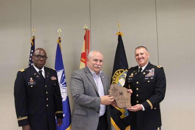 Chaplain (Maj.) Robert Rand with the garrison Religious Support Office; the Rev. Robert Rand, guest speaker and retired chaplain and colonel; and Garrison Commander Col. Michael Poss show an appreciation plaque presented to Brandt at the Memorial...