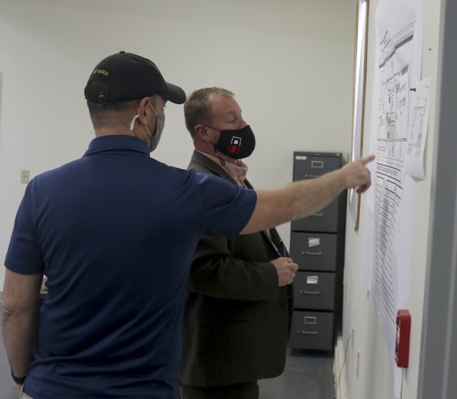 John Bowyer, left, project lead and senior network engineer, Security Applications International Corporation, explains the Mission Command Configuration Center (MC3) layout to Brandon Strait, program manager, SAIC, at Fort McCoy, Wis., April 20,...