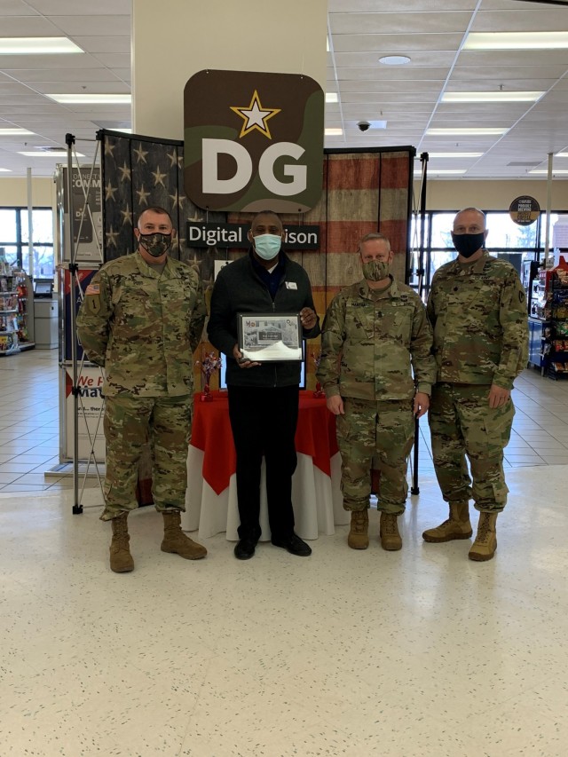 Col. Michael Poss, Fort McCoy garrison commander; Donald Basil, general manager of the Fort McCoy Exchange; Command Sgt. Maj. Paul Mantha; and Deputy Garrison Commander Lt Col. Alex Carter pose with a plaque given to honor the Exchange.