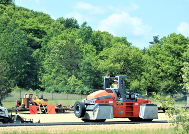 Contractors put down pavement June 2, 2021, on a road near Pine View Campground at Fort McCoy, Wis. The work is part of many types of roadwork taking place on post in 2021. The work is coordinated by the Fort McCoy Directorate of Public Works....