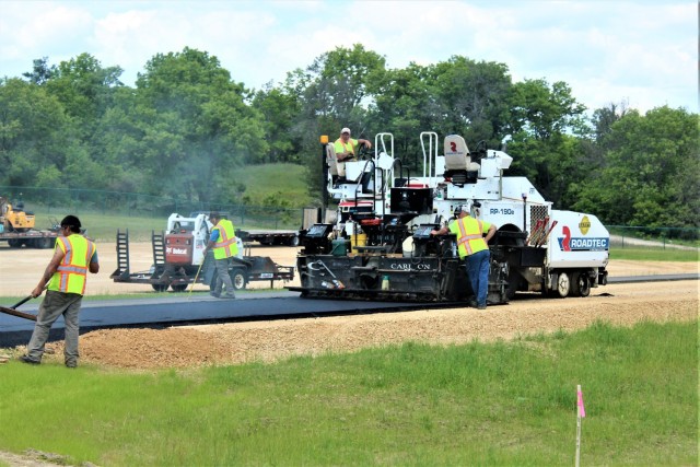 Contractors put down pavement June 2, 2021, on a road near Pine View Campground at Fort McCoy, Wis. The work is part of many types of roadwork taking place on post in 2021. The work is coordinated by the Fort McCoy Directorate of Public Works....