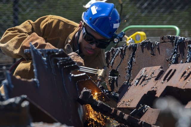U.S. Air Force Staff Sgt. Sadonta Cole, a firefighter with the 188th Wing at Ebbing Air National Guard Base in Fort Smith, Ark., cuts metal with a torch during the PATRIOT 21 exercise at Volk Field Combat Readiness Training Center, Wis., June 13, 2021. The annual exercise provides a simulated natural disaster environment for units to test their response and capabilities. (U.S. Air National Guard photo by Staff Sgt. Wendy Kuhn)