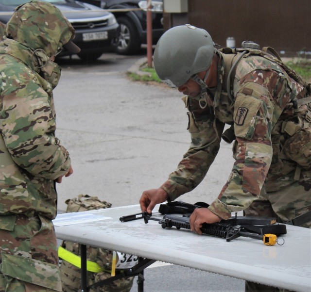 Capt. David Johnson, right, commander of the 75th Medical Company (Area Support), and Dr. (Maj.) Edward Chang, a head and neck surgeon with the Brian D. Allgood Army Community Hospital and Command Surgeon of the 19th Expeditionary Sustainment Command, complete the final task of disassembling the M4 carbine as part of the Expert Field Medical Badge competition, May 21, 2021, at Rodriguez Multi-Purpose Live Fire Complex, commonly known as Rodriquez Range. Chang and Johnson were the only two to be awarded the EFMB out of over 100 candidates.
