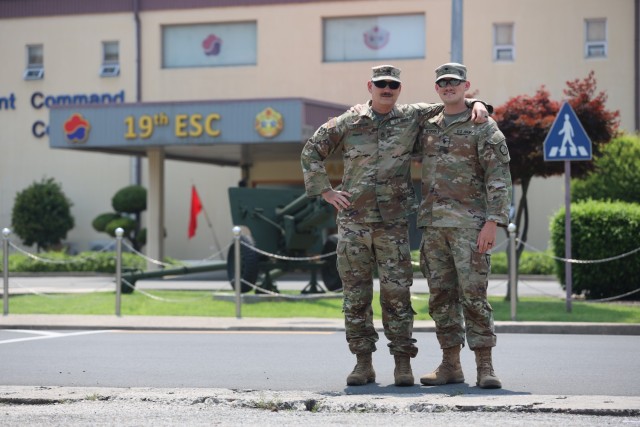 Staff Sgt. Galen Peterson, left, an ammunition NCO with Distribution Management Center, 19th Expeditionary Sustainment Command, poses with his son Spc. Justin Peterson, a Religious Affairs Specialist with 94th Military Police Battalion, in front of 19th ESC headquarters on Camp Henry. After growing up as an Army brat, Spc. Peterson enlisted in the Army in 2018 and now father and son are both stationed in Korea.