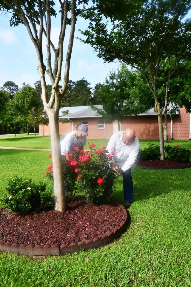 Vickey Stevenson, horticultural attendant (left) and James Armes III, Central Louisiana Veterans Cemetery director, inspect a rose bush and shrubs to make sure they don’t need pruning or fertilizer, as well as the landscaping for weeds that need to be removed.
