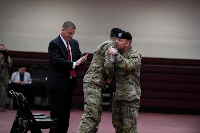 CAMP HUMPHREYS, Republic of Korea - Col. Michael F. Tremblay, right, the outgoing garrison commander for United States Army Garrison Humphreys, embraces the incoming garrison commander, Col. Seth C. Graves, during a change of command ceremony here, June 15. The change of command ceremony formally bid farewell to Tremblay, whose two years as garrison commander saw extensive COVID-19 mitigation measures and wide efforts to strengthen community ties.