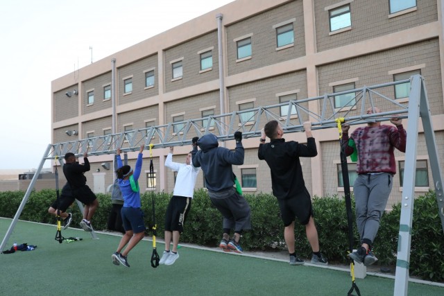 Maj. Anthony Sims-Hall, 1st Theater Sustainment Command, theater mortuary affairs officer, leads a functional fitness workout for Soldiers at Camp Arifjan, Kuwait. Maj. Sims-Hall takes personal passion and hobbies and turns them into resiliency opportunities for Soldiers while deployed. (U.S. Army photo by Capt. Elizabeth Rogers)