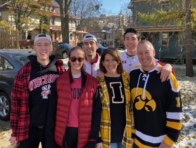 The Kelly family tailgating at Iowa vs. Wisconsin Football Game. The three Kelly sons are all undergrad graduates of University of Wisconsin at Madison and either are or in training to be Army physicians. The back row (left to right) Connor Kelly, Ethan Kelly, Grant Kelly; front row (left to right) Hannah Kelly, Kathy Kelly, and Brett Kelly.