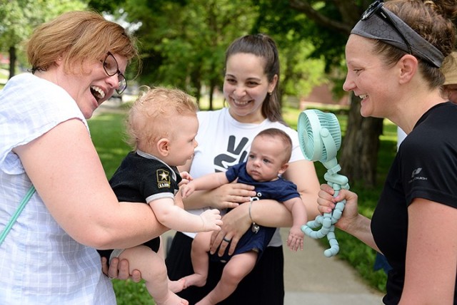 Kara Tobin, New Parent Support Program home visitor and registered nurse, holds Cyndi DePaul’s 3-month-old son Luke as DePaul holds a fan on him as they talk with Daniella Bello, mom of 3-month-old River, after the NPSP’s Stroller Walk and...