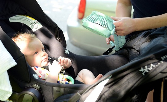 Leah Kahn cools Cyndi DePaul’s 3-month-old son, Luke, with a fan during the New Parent Support Program’s Stroller Walk and Talk June 11 along the walk route near Main Parade. Photo by Prudence Siebert/Fort Leavenworth Lamp