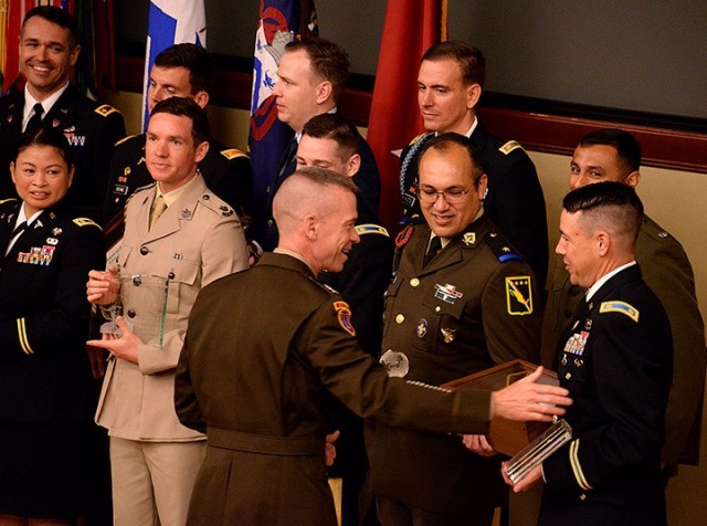 Maj. Gen. Donn Hill, deputy commanding general for education, Combined Arms Center, congratulates Command and General Staff Officer Course award recipients, including multiple award recipient Maj. Spencer French, right, as they assemble for a...
