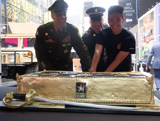 Commandant of the Corps of Cadets, Brig. Gen. Mark Quander, cuts a cake with the youngest and oldest military service members in attendance during the 246th Army Birthday celebration Monday at Times Square in New York City.