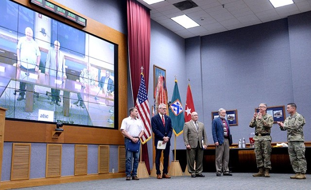 Lt. Gen. Theodore Martin, Combined Arms Center and Fort Leavenworth commanding general, and CAC and Fort Leavenworth Command Sgt. Maj. Stephen Helton, right, applaud civilians Charles Barker, CAC-Training, and Barry Buchanan, CAC-T — attending...