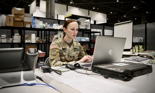 A service-wide migration to Army 365 was completed June 16 to provide Soldiers and Army civilians a cloud-based capability that will bolster collaboration and connectivity. In the photo, Capt. Kelly Spencer, a brigade nurse and the officer-in-charge of a minimal care ward at the Seattle Event Center, Wash., checks her email at the nurse’s station, April 6, 2020. (Sgt. 1st Class Brent Powell)