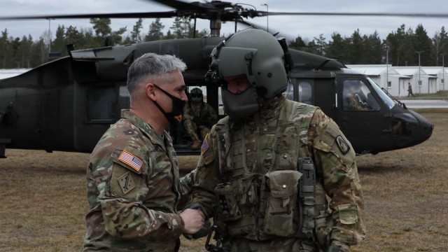 U.S. Army Reserve Col. Carlos E. Gorbea (left), commander of the 361st Civil Affairs Brigade, 7th Mission Support Command, presents his unit’s coin to U.S. Army Sgt. Derek J. Born, a critical care flight paramedic with Charlie Company, 1st Battalion, 214th Aviation Regiment (General Support), 12th Combat Aviation Brigade, in appreciation of aircraft medical evacuation training performed by his team for more than 50 Army Reserve Soldiers at Camp Normandy, United States Army Garrison Bavaria in Grafenwoehr, Germany, April 10, 2021.