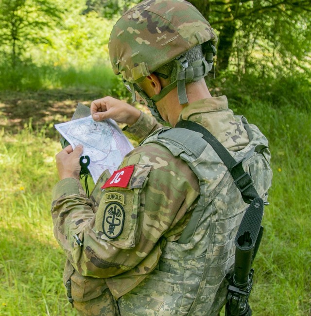 Capt. Jason Christman, an optometrist with the Desmond Doss Health Clinic in Hawaii, plots coordinates during the land navigation portion of the Regional Health Command - Pacific best leader competition, at Joint Base Lewis-McChord, Wash., June...