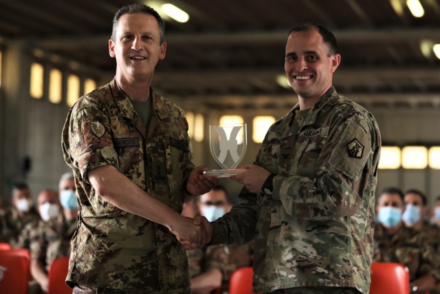 U.S. Army Reserve Col. Greg Gimenez, commander of the 2500th Digital Liaison Detachment, 7th Mission Support Command, right, presents Maj. Gen. Nicola Terzano, commander of the Italian Army´s Divsione Acqui, a unit friendship award during exercise DEFENDER-Europe 21 in Capua, Italy, June 14, 2021. The 2500th embedded with the Divisione Acqui to help with liaison support of the U.S. Army´s V Corps and Joint Force Land Component Command during the exercise.