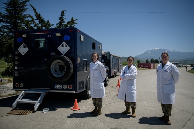 Three members of the laboratory covid testing team (left) Capt. Fawn OLeary, Medical Service Officer, (middle) Capt. Shawna So, Chemical Officer and (right) Maj. Brooke Spridgen, Lab Officer, assigned to 773rd Civil Support Team, 7th Mission Support Command, all take a well deserved break while administering COVID 19 testing during DEFENDER-Europe 21 at Kucove, Albania, May 19, 2021. Approximately 800 Army Reserve Soldiers from the U.S. and Europe are participating in DEFENDER-Europe 21, a large-scale U.S. Army-led exercise designed to build readiness and interoperability between the U.S., NATO allies and partner militaries. (U.S. Army photo by Staff Sgt. Thomas Mort)