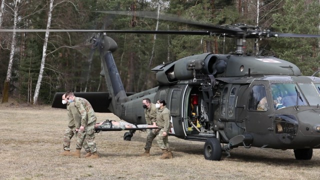 U.S. Army Reserve Soldiers from the 361st Civil Affairs Brigade, 7th Mission Support Command, perform medical evacuation training with aviation Soldiers from Charlie Company, 1st Battalion, 214th Aviation Regiment (General Support), 12th Combat Aviation Brigade, at Camp Normandy, United States Army Garrison Bavaria in Grafenwoehr, Germany, April 10, 2021.