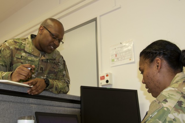 Cpt. Sibusiso Ntuli, left, health service systems management officer with 3rd Medical Command (Deployment Support) speaks with Cpt. Jessica Bradford, patient administration officer with the 3rd MC (DS) about future operations during a medical command post exercise, part of Defender Europe 21, on Daenner Kaserne in Kaiserslautern, Germany June 11, 2021. Defender Europe 21 is an annual large-scale U.S. Army Europe and Africa-led joint, multinational exercise designed to build readiness and interoperability between U.S., NATO and partner militaries.  (U.S. Army photo by Staff Sgt. Chris Jackson)