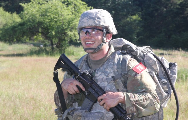 Sgt. Patrick Cook, assigned to U.S. Army Medical Department Activity-Alaska, smiles as he moves out towards the Army Warrior Tasks lanes during the Regional Health Command-Pacific Best Leader Competition, Joint Base Lewis-McChord, Wash., June 17,...