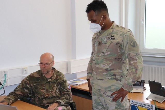 U.S Army Reserve Staff Sgt. Deshawn Daniel, country desk officer for the Joint Security Coordination Center, 7th Mission Support Command, right, synchronizes information with NATO Joint Support and Enabling Command Lt. Col. Marko Unger on Panzer Kaserne in Kaiserslautern, Germany, May 27, 2021. U.S. Army Reserve Soldiers and Civilians assigned to the7th MSC teamed up with NATO Allies and partners from 18 different countries to provide a unique protection capability for U.S. Army Europe and Africa by serving as the JSCC in support of DEFENDER Europe 21. (U.S. Army Reserve Photo by Capt. Lorenzo Llorente)