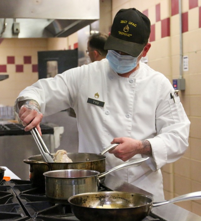SSG David Tyo, Echo Company, 39th BEB, 2nd Brigade Combat Team, 101st Airborne Division (AASLT), cooks a canned chicken, one of the mystery ingredients given to each contestant each round, during the 2021 Week of the Eagles culinary competition....