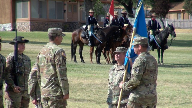 (right) Col. Loren Traugutt, Commander, 111th Military Intelligence Brigade passes the unit colors to (left) Lt. Col. Adam Forrest, the incoming Commander of the 305 Military Intelligence Battalion as the outgoing Commander Lt. Col. T.J. Fearnow looks on at a change of command ceremony on Brown Parade Field at Fort Huachuca, Ariz.