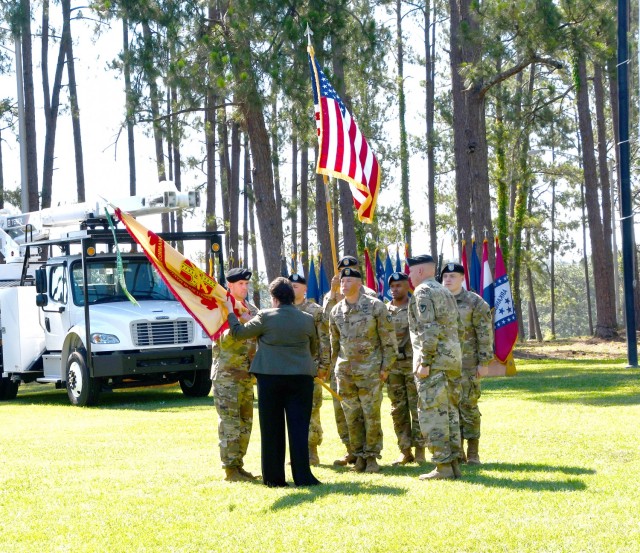 Brenda McCullough, director, IMCOM-Readiness, passes the Fort Polk Garrison colors to Col. Sam Smith, incoming garrison commander, during a change of command ceremony June 18 at Fort Polk's Warrior Field, as outgoing commander, Col. Ryan K. Roseberry looks on.