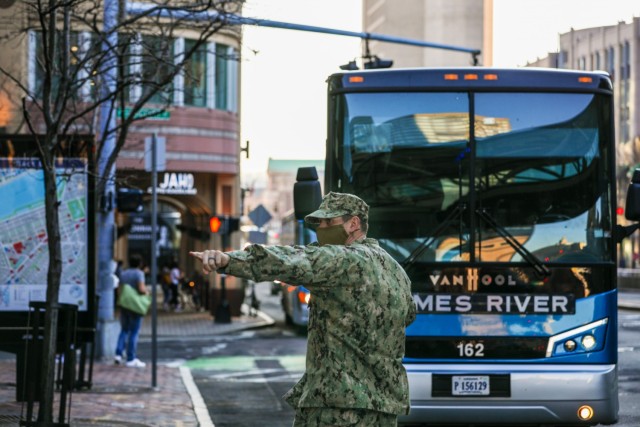 U.S. Navy Chief Master at Arms George Yonitch, from Navy Cargo Handling Battalion ONE (NCHB1), directs buses full of Sailors from Virginia as they arrive in Boston, March 26, 2021. U.S. service members from across the country are deployed in...