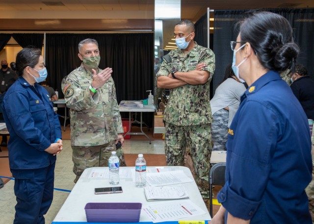 Joint Task Force Civil Support Commanding General U.S. Army Maj. Gen. Jeff Van, middle, speaks with U.S. Public Health Service Lt. Cmdr. Jina Kwak, a pharmacist, right, during a tour of the state-run, federally-supported COVID-19 community...