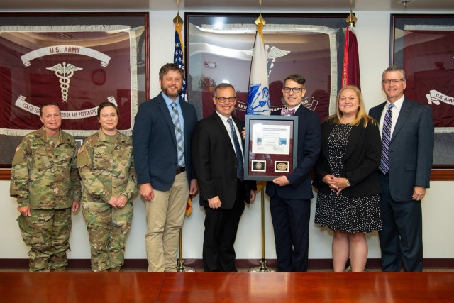 Col. Jennifer McDannald, director Army Public Health Center, poses for a group photo with APHC COVID-19 Task Force members Maj. Kerry Kingless, Tom Sherwood, Steve Starbuck, Ginn White, Essie Pfau, and Dr. Steven Cersovsky, APHC deputy director, during the Second Quarter Fiscal Year 2021 Army Medicine Wolf Pack Award Ceremony held virtually and in person at Aberdeen Proving Ground, Maryland, June 17. The Wolf Pack Award was created by the 43rd Army Surgeon General and the 4th Chief of the Army Medical Department Civilian Corps to recognize exceptional teamwork by an integrated group of Army Medicine civilian and military team members who have demonstrated excellence in support of the Army Medicine mission. (U.S. Army Public Health photo by Graham Snodgrass)