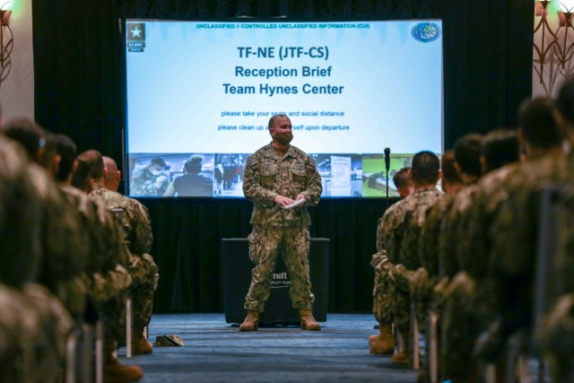 Lt. Cmdr. Aaron Piontek, assigned to Navy Cargo Handling Battalion ONE, Williamsburg, Virginia, briefs U.S. service members during in-processing March 27, 2021, Boston. U.S. service members from across the country are deployed in support of the...