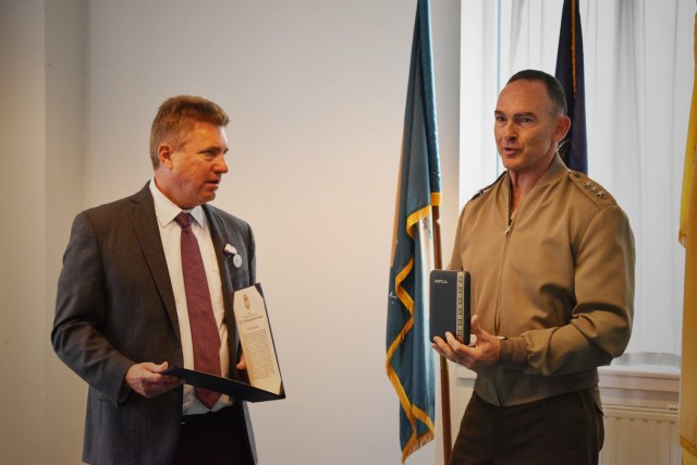 ZAVENTEM, Belgium – U.S. Marine Corps Lt. Gen. John K. Love, right, senior U.S. military representative at NATO, presents Dr. Jerome Sheridan, president of the American Overseas Memorial Day Association Belgium, an outstanding public service award from the Chairman of the Joint Chiefs of Staff, during an AOMDA Belgium meeting June 22 at U.S. Army Garrison Benelux – Brussels. (U.S. Army photo by Bryan Gatchell, USAG Benelux Public Affairs)